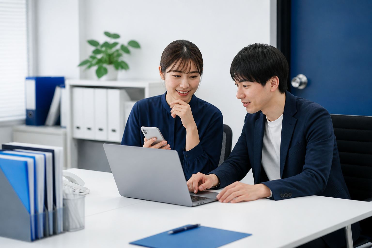 SNS投稿とアカウントを二人で確認する広報スタッフ
