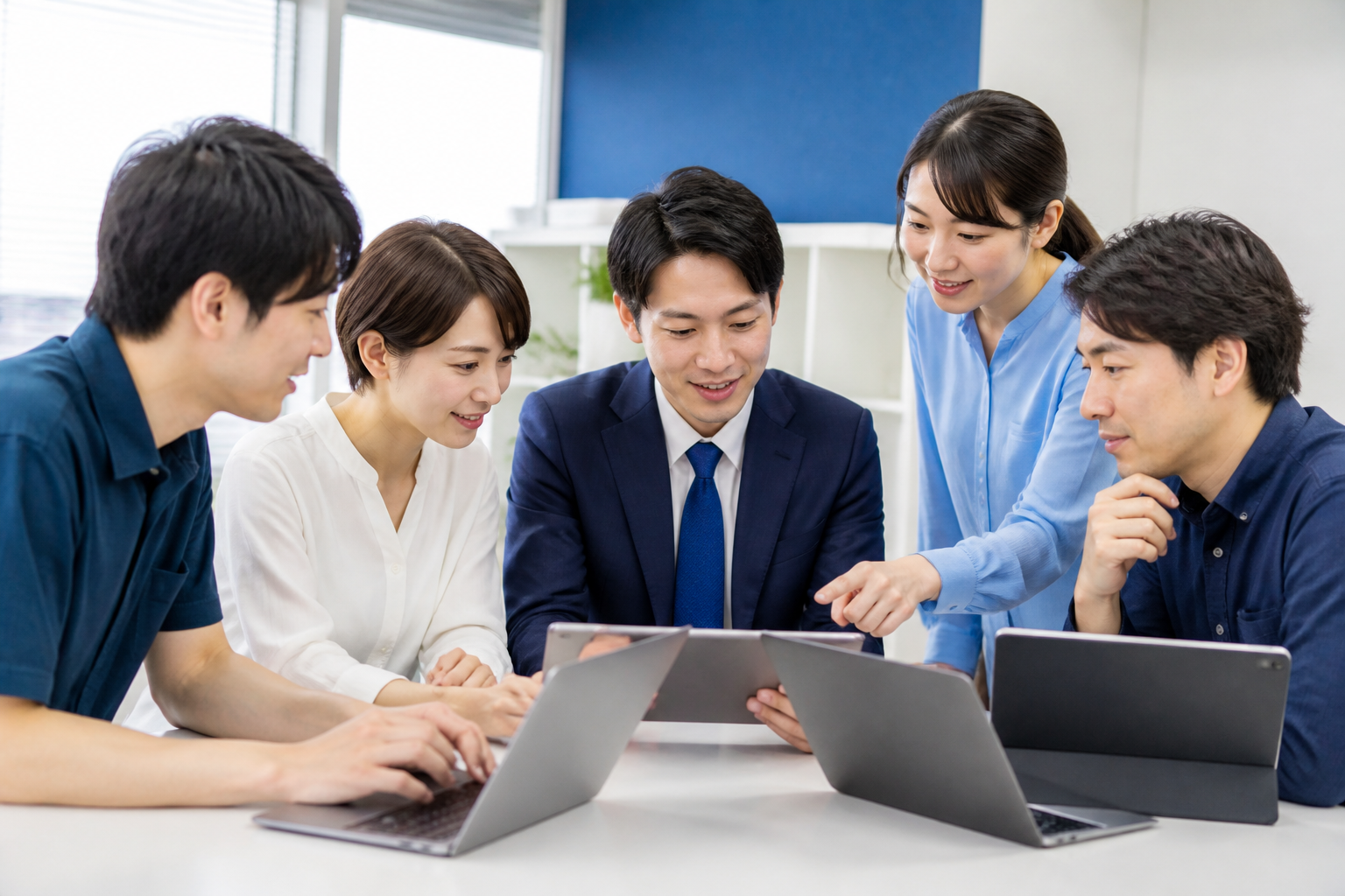 選挙事務所でSNS投稿前の写真を複数人で確認する様子