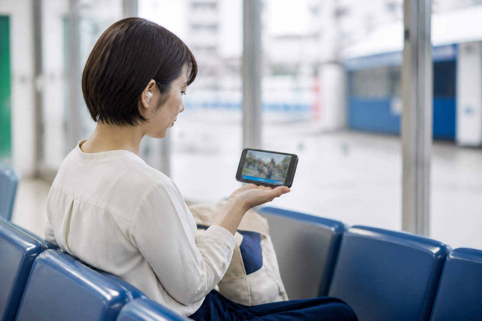 公共の場所でスマートフォンの地域活動動画を無音視聴する住民