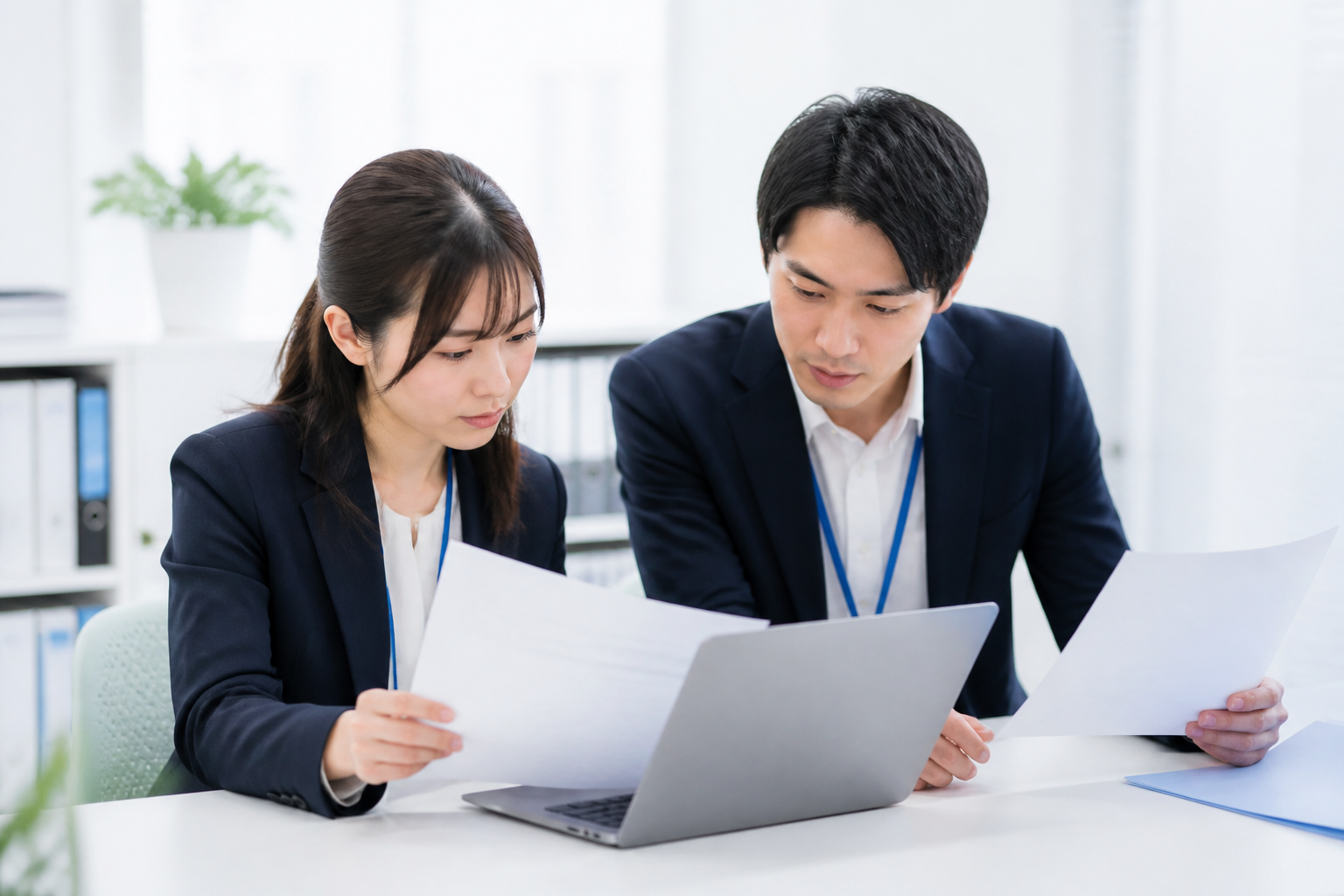 資料を見比べてSNS原稿の事実確認をするスタッフ