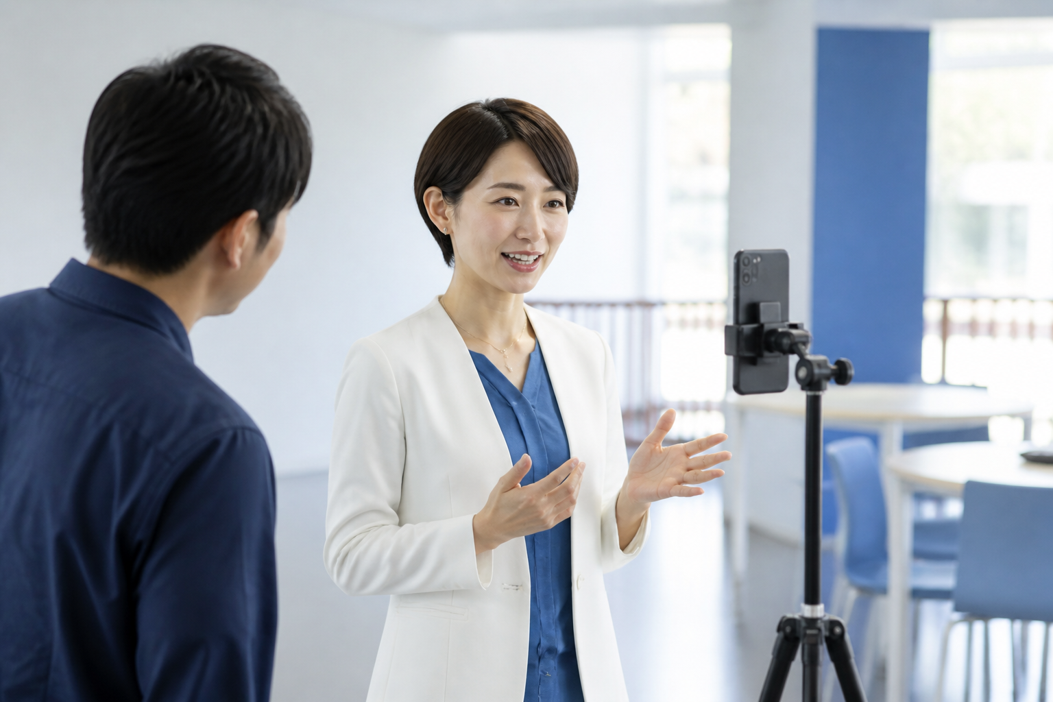 スタッフの支援を受けながら自然な話し方で動画を撮影する政治活動関係者
