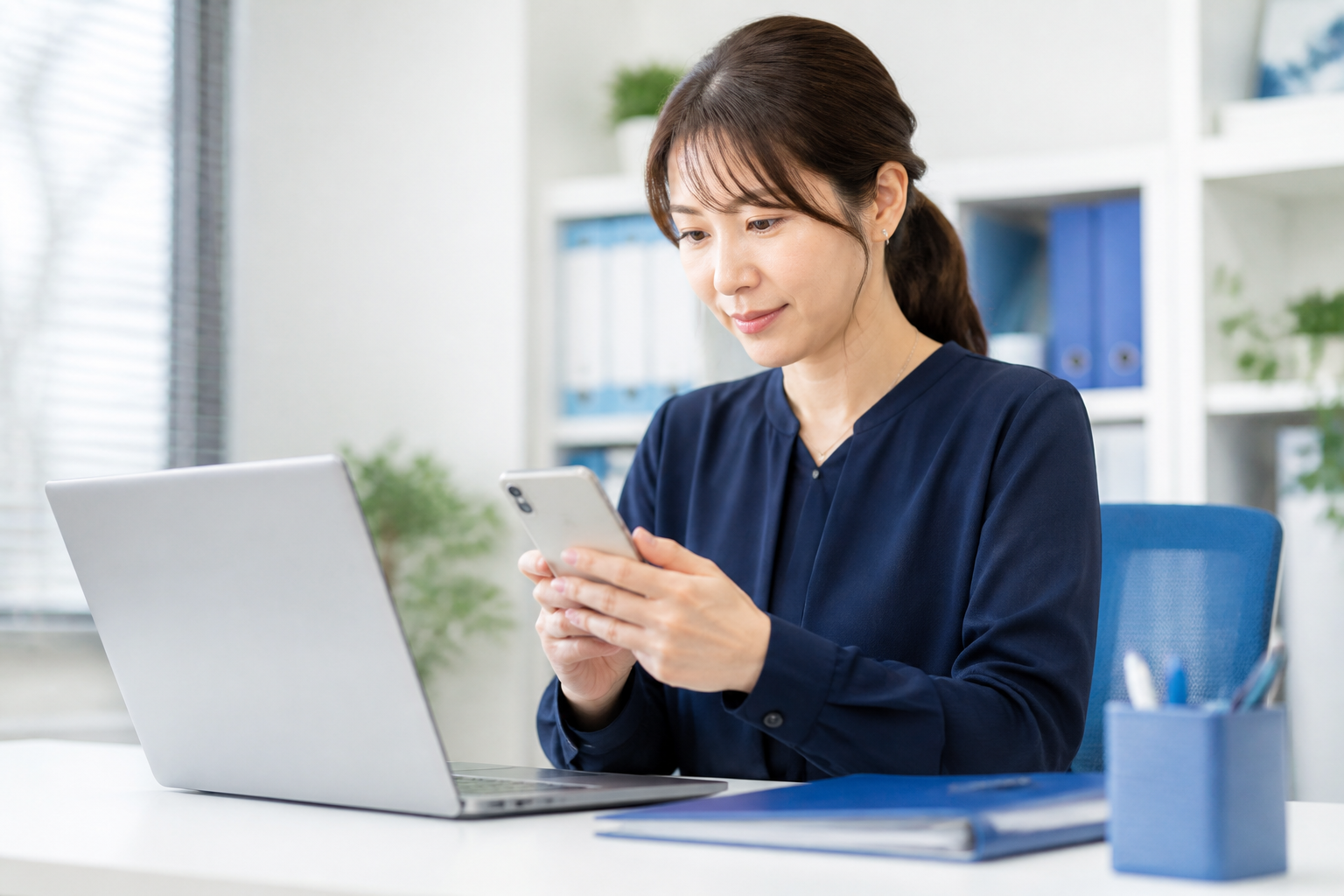 スマートフォンで簡潔な返信文を確認する広報担当者