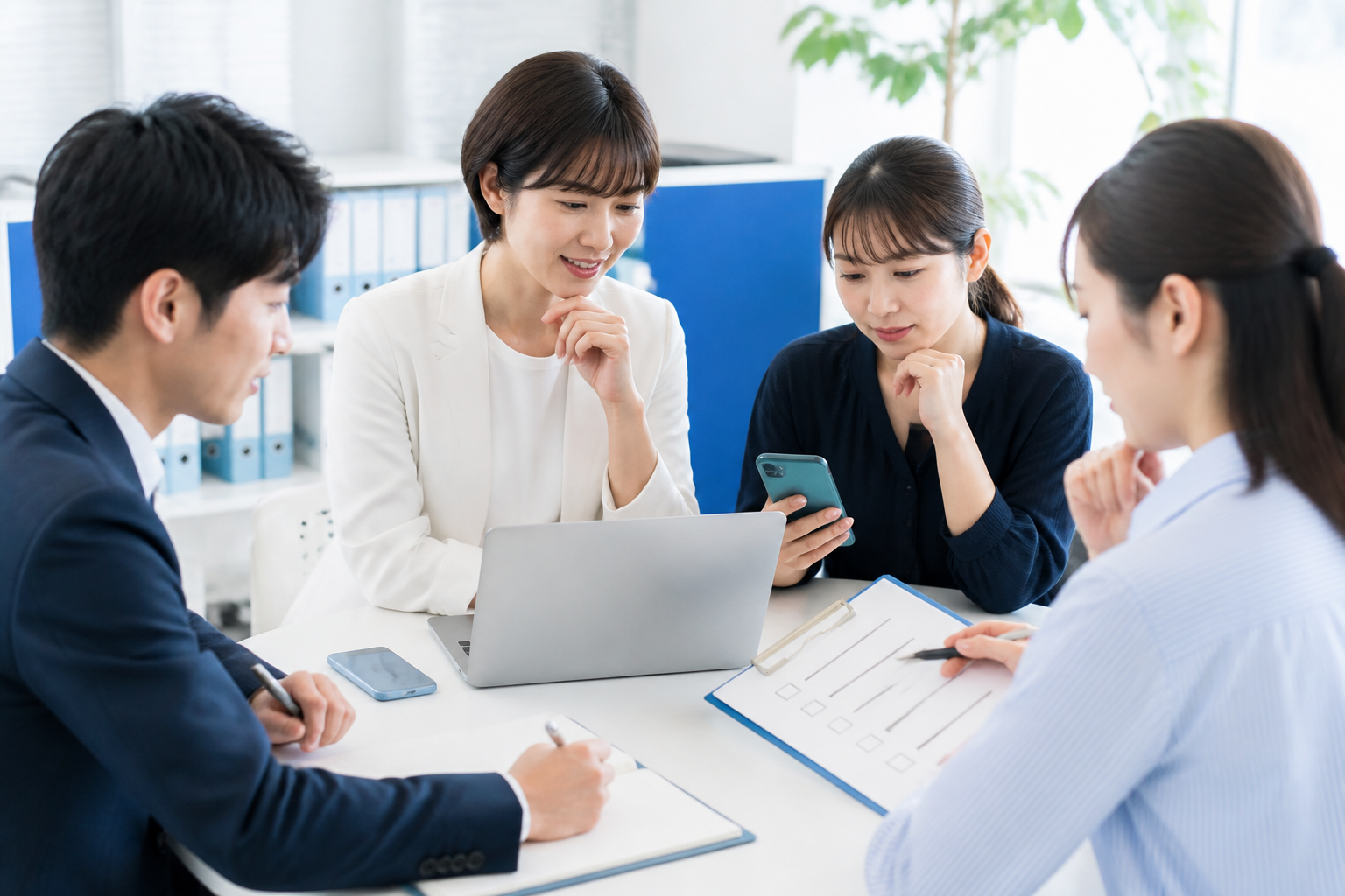 事務所でSNSアカウントの安全管理と投稿確認のルールを話し合う候補者とスタッフ