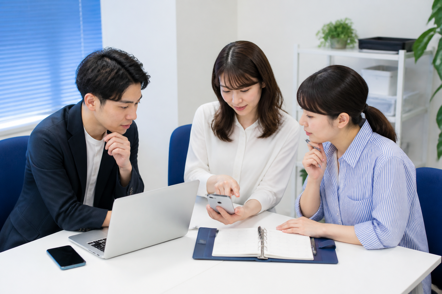 SNS投稿の役割分担と承認手順を相談する事務所スタッフ