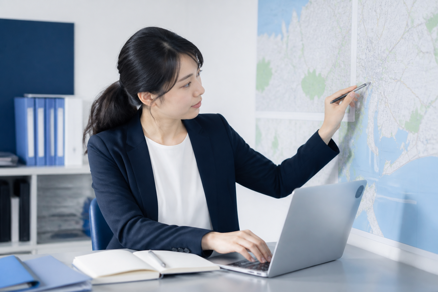 地域地図を見ながら広域選挙区の訪問計画を整理する広報担当者