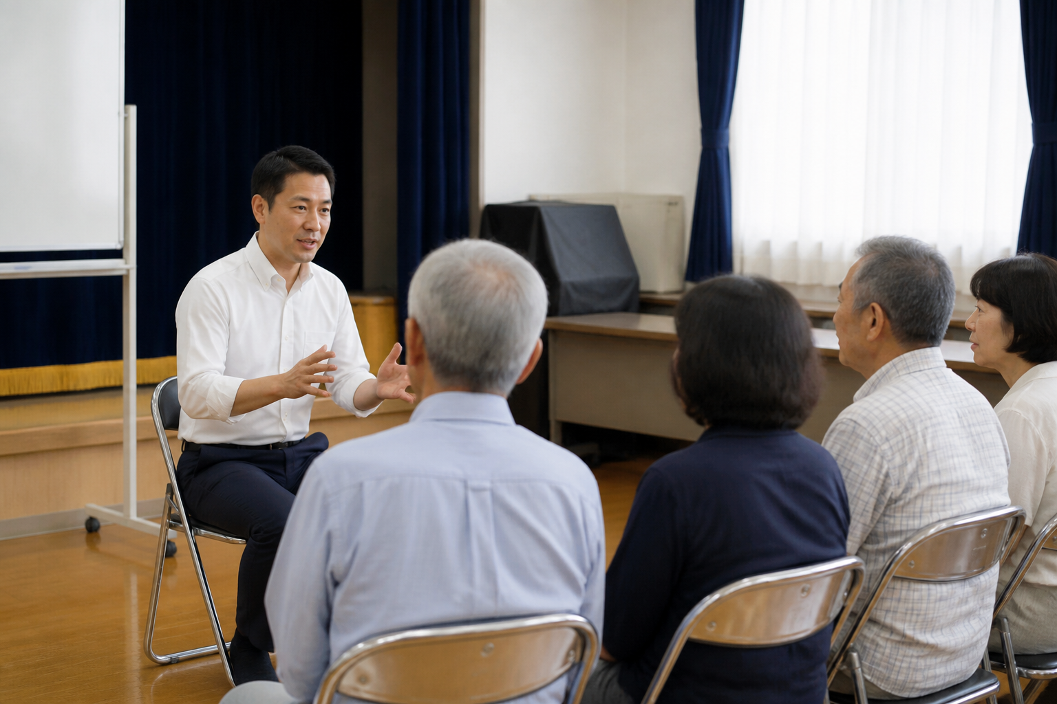 地域集会所で住民に活動方針を説明する政治活動関係者