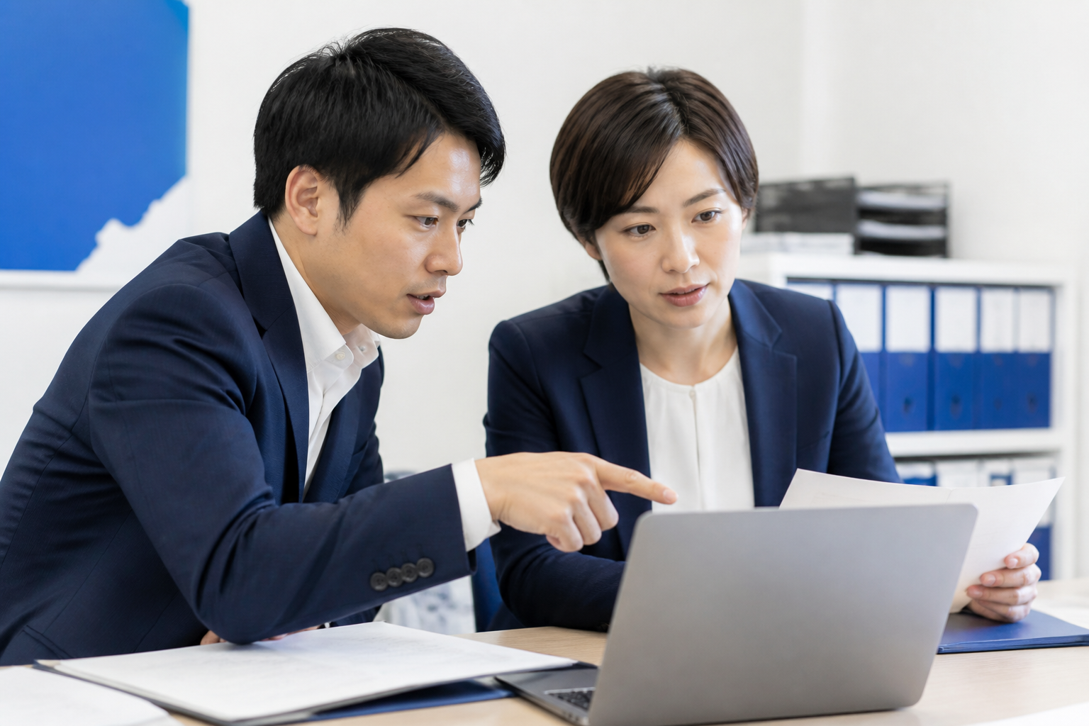 選挙運動のルールと公的情報を確認する事務所スタッフ